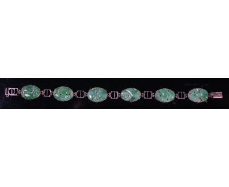 A white metal and jade sectional bracelet, as six Chinese celadon jade relief carved oval panels, on pierced square dividers 