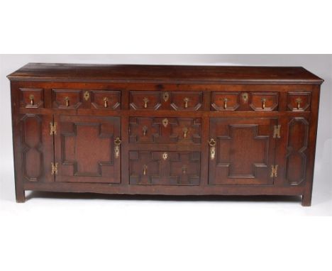 An early 19th century geometric moulded oak dresser base, in the Jacobean style, having an arrangement of five frieze drawers