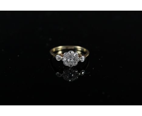 An 18ct platinum set diamond cluster ring of floral form with diamond set shoulders, size R