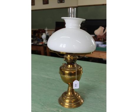 A vintage brass oil lamp with white glass shade