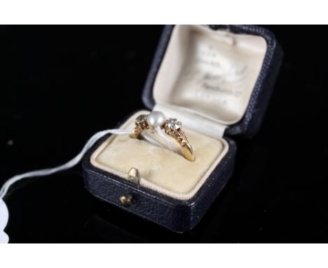 A diamond and pearl ring, the centre diamond flanked by an old cut diamond either side (each approx 0.25cts), ring marks are 