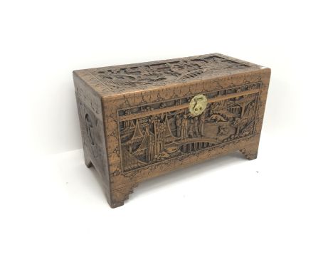 Early 20th century camphor wood chest, hinged lid with clasp and stay, heavily carved depicting town scene, shaped bracket su