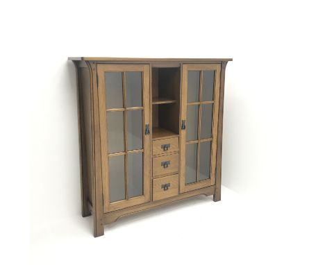 Arts & Crafts style oak cabinet, two glazed doors flanking single shelf and three graduating drawers, stile supports, W130cm,