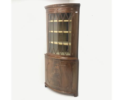 20th century figured mahogany bow front corner cabinet, projecting cornice, dentil frieze, single door enclosing three lined 