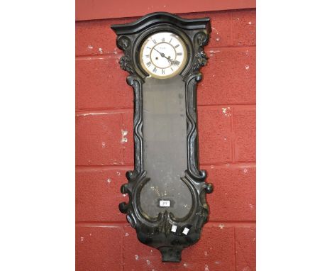 A late Victorian ebonised wall clock, slightly arched pediment, carved scrolling case, clear glass door, white enamel dial, t