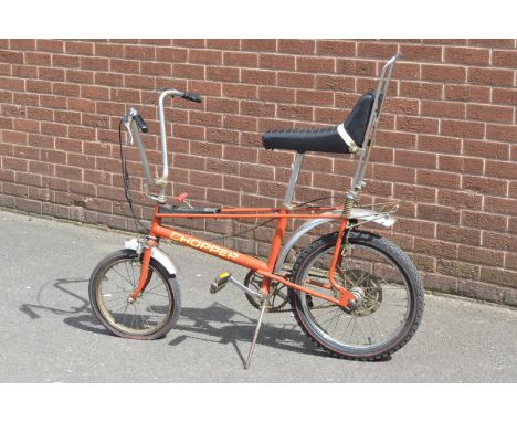 A vintage Chopper bicycle in blazing orange, three speed stick shift, original specification.