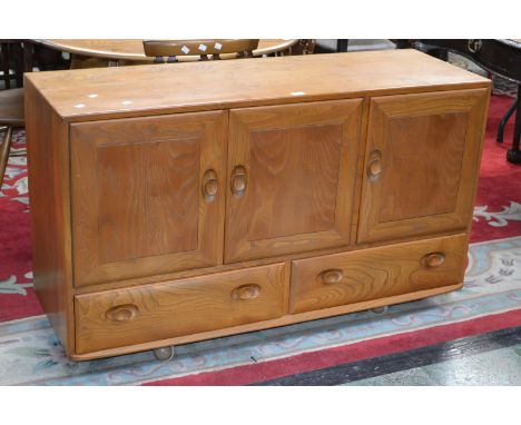 A Ercol Windsor sideboard, three panel door cupboard over two long  drawers.