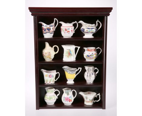 A SET OF TWELVE ROYAL WORCESTER "HISTORICAL COLLECTION" JUGS, on a mahogany effect wall-hanging display shelf. Shelf 53cm hig