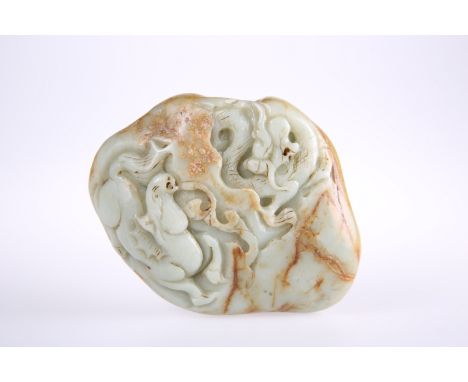 A LARGE CHINESE JADE CARVING, the irregular shaped stone carved to the top with a horse and dragon. 12.5cm by 10cm