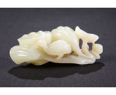 A CHINESE CELADON JADE CARVING, carved with a bird and foliage. 7.5cm long