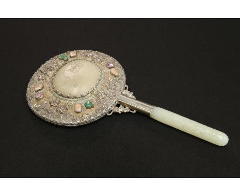 A CHINESE WHITE-METAL AND JADE HAND MIRROR,&nbsp;with celadon jade handle carved with a chilong, the oval mirror back with ce