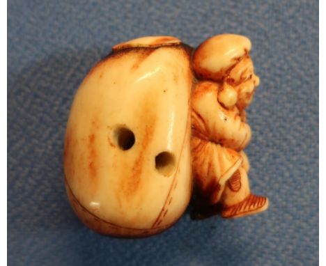 19th C carved ivory Netsuke in the form of a Dutchman  carrying a sack (height 4cm) 