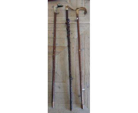 Three Shepard style sticks, two with carved sheep horn handles, one with a fish and the other a badger, and a twisted wood st