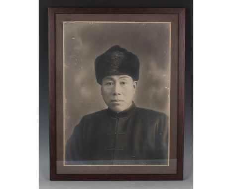 A Chinese black and white photograph, probably early 20th century, depicting a half-length portrait of a gentleman wearing a 