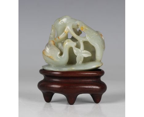 A Chinese celadon jade carving, probably 20th century, carved and pierced as a mandarin duck and duckling grasping lotus stem