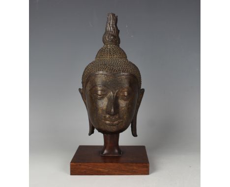 A Thai bronze Buddha head, possibly 17th century, modelled with tightly curled hair rising to a domed unisa and flame surmoun