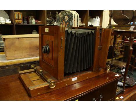An early 20th century mahogany-case folding camera, with retailers plaque for "City Sale &amp; Exchange, Fleet St, concertina
