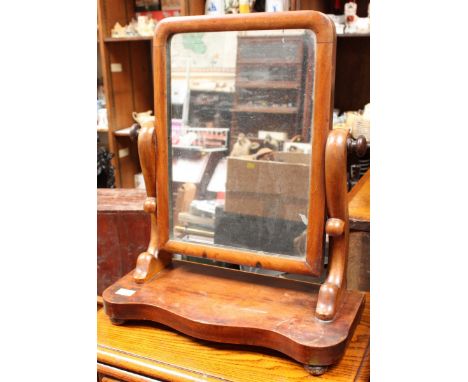 A 19th century mahogany platform mirror with cushion-moulded frame and serpentine base.  50cm high