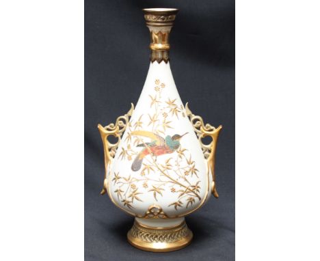 A Royal Worcester vase, pierced handles and blush ivory body, heavily gilt decoration of an exotic bird amongst leafy branche