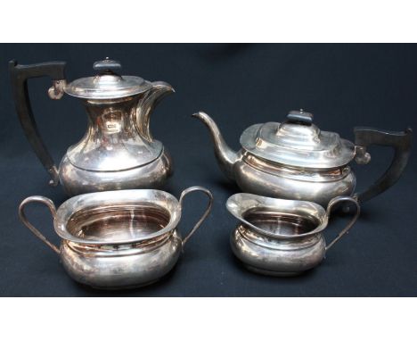 A George VI four piece silver tea set comprising, tea pot, coffee pot, milk jug and sugar bowl, of plain form with ebonised h