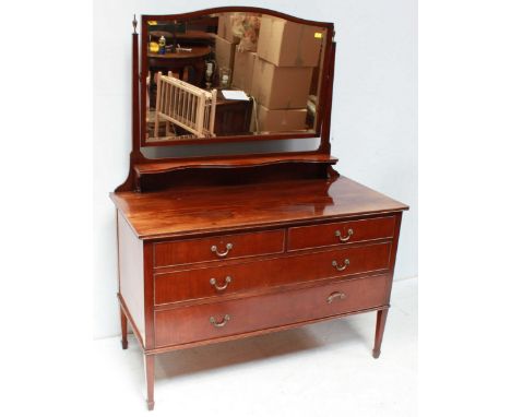 An Edwardian mahogany dressing table with large swing mirror and shelf over a base of three long graduated drawers with brass