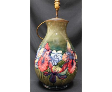A large Moorcroft pottery Orchid pattern table lamp decorated with various tube lined flowers on a green ground impressed mar