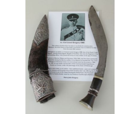 A Ghurka officer's dress kukri, with white metal mounted scabbard, companion knives and cow horn handle, bearing the regiment