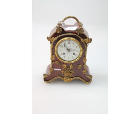 A French late 19th/early 20th century eight-day red boule mantel clock, with applied gilt metal mounts, fitted an ogee enamel