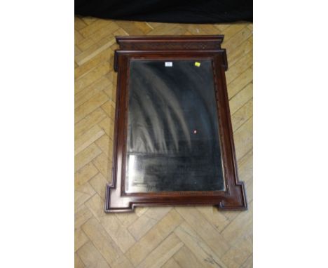 An Edwardian mahogany wall mirror, having a blind fret frieze over inverted break front frame, with bead moulding enclosing a