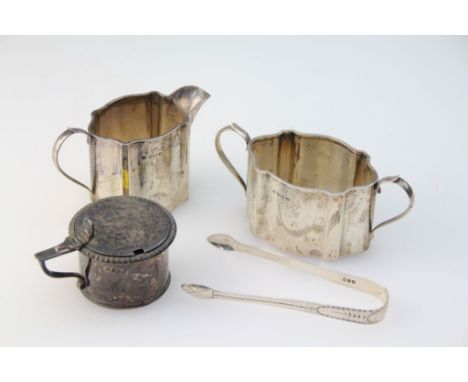 An early 20th century silver cream jug and sugar basin, cartouche shaped with scrolling side handles, Birmingham 1926, togeth