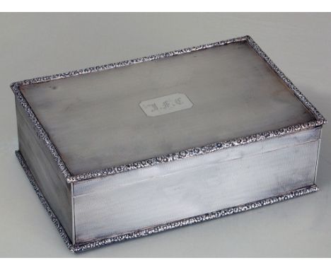 A large silver and gilt table cigarette box, rectangular engine turned with cast floral borders, monogram engraved to cover, 