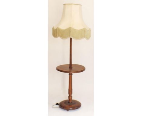 A walnut standard lamp with integral occasional table and carved base 