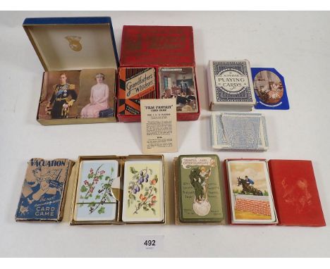 A tray of seven antique and vintage playing cards, some un-opened, a vintage 'Valuation' card game with instructions and a vi