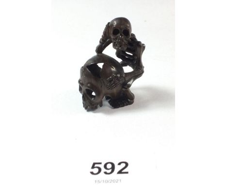 A signed carved wood netsuke in the form of a skull and skeleton 