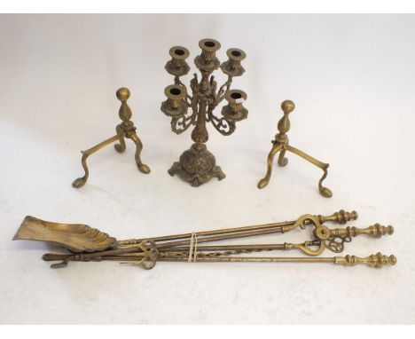 A brass candelabra and three piece fire iron set, a pair of fire dogs and toasting fork 