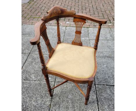 An Edwardian walnut corner chair, having shaped inlaid pillow back, out scrolled spatulate arms, reticulated spats, ring turn