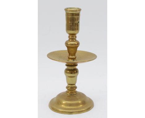 A mid 17th Century Dutch cast brass 'Heemskirk' candlestick, with turned stem, wide central drip pan and mound base, 20.5cm.