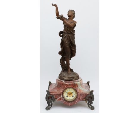 A late 19th century French figural mantel clock, the dial set in a rose mottled marble body, raised on scroll legs, the whole