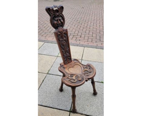 An early 20th century Welsh oak carved spinning chair, of typical form, raised on turned tapering legs, the back splat carved