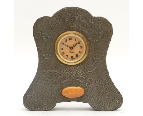 An Arts &amp; Crafts pewter mantel clock, the shaped case with floral decoration and inset ruskin plaque, painted dial with A