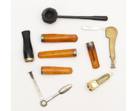 An Irish bog oak carved cauldron pipe, a 9ct gold mounted amber cheroot holder, Birmingham 1907, two silver mounted examples 