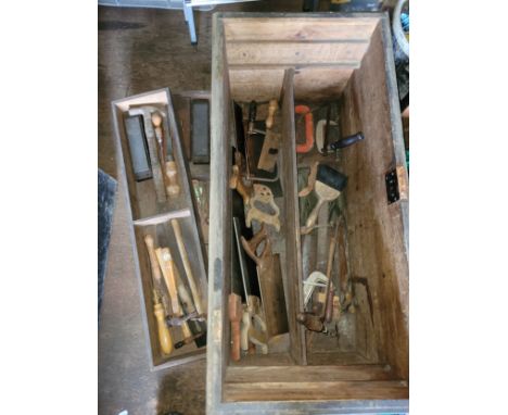 A large wooden toolbox containing a collection of carpenters hand tools. 