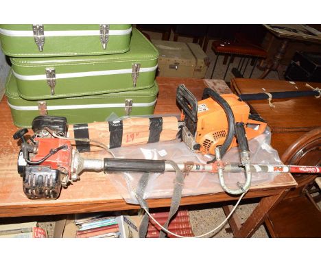 Swiss Kraft International chainsaw together with a petrol strimmer