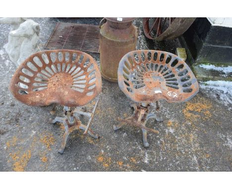 Pair of iron bar stools with tractor style seats