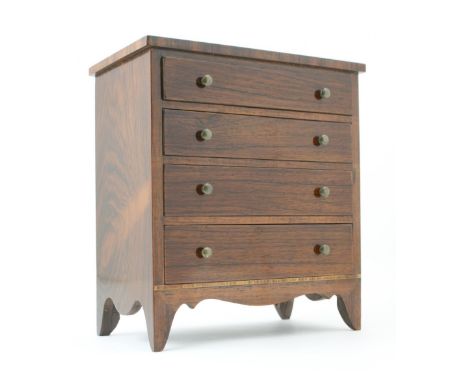 Rosewood miniature chest of drawers in the Regency style, fitted with four graduated drawers with brass knobs, over a shaped 