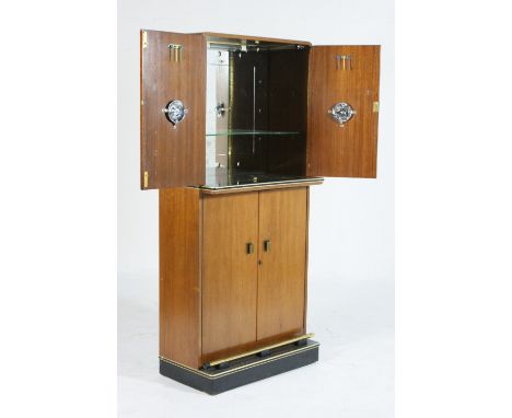 Vintage teak cocktail cabinet, circa 1955, having two upper doors opening to a mirrored interior, over a base fitted with a f