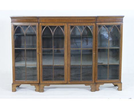 Edwardian mahogany breakfront bookcase, in the Georgian style, having four Gothic arched astragal glazed doors opening to adj