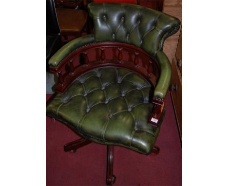 A reproduction mahogany and green leather button back studded revolving tub desk chair