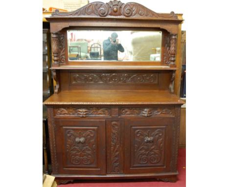 A good late 19th century heavily carved oak mirrorback sideboard, the upper section having integral shelf 