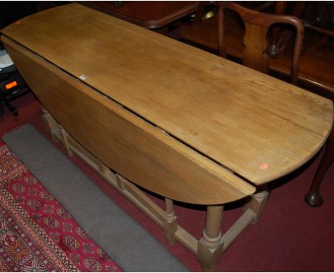 A light oak drop leaf wake table having double gateleg action